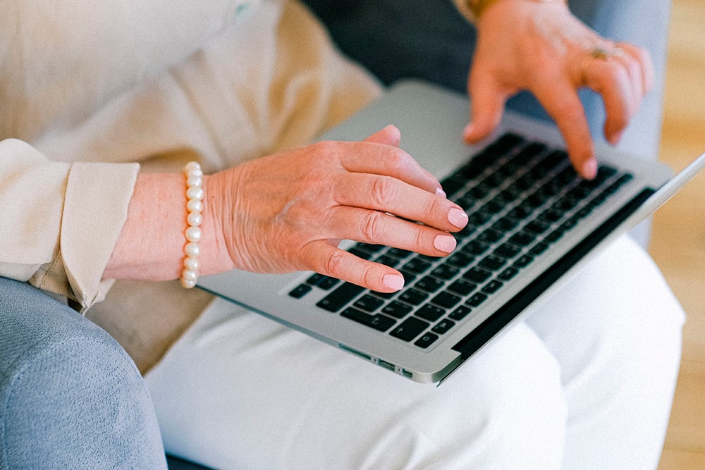 Personer sidder og skriver på sin bærbare computer